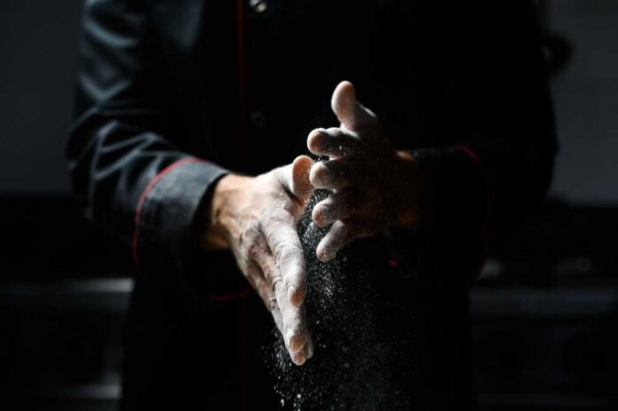 Close-up,Of,A,Chefs,Hands,Scattering,Fine,White,Flour,,With