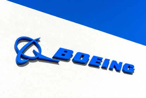Boeing logo on a white building, blue sky.