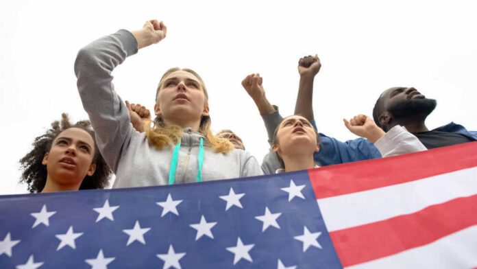 People raising fists with American flag nearby.