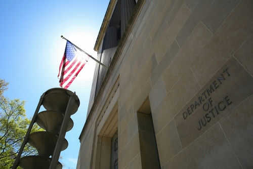 doj-2152403209 United States flag Department of Justice building exterior