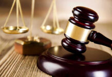 Election Integrity Advocates Face Legal Onslaught Wooden gavel and scales of justice on table