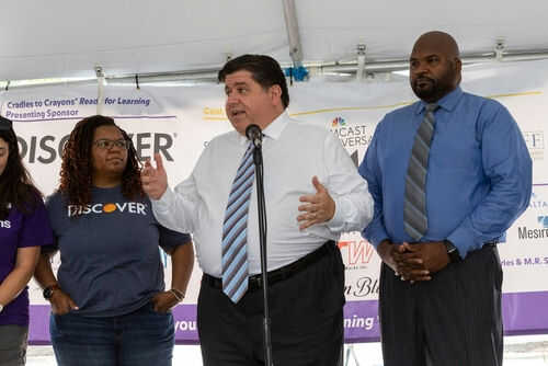 Three people speaking at a promotional event.