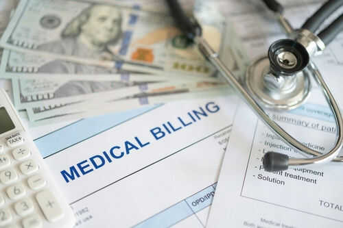 Stethoscope calculator and money on medical billing papers