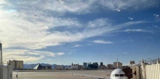 Airport runway with airplane and Las Vegas skyline.