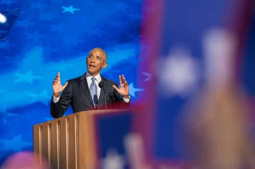 Man speaking at podium with blue starry background