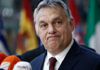 Orbán’s EU Battle: Trump’s SHOCKING Support A political figure speaking at a press conference with microphones in front