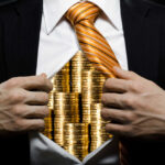 Businessman revealing gold coins under his shirt