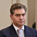 A journalist with a serious expression at a press conference