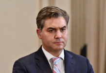 A journalist with a serious expression at a press conference