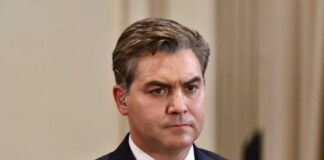 A journalist with a serious expression at a press conference