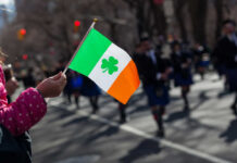 Child holding an Irish flag during a parade
