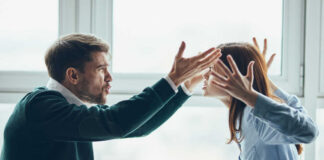 Two individuals engaged in a heated argument in an office environment
