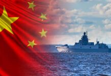 A Chinese naval ship sailing on the ocean with the Chinese flag in the background
