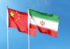 Flags of China and Iran waving against a blue sky