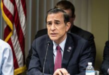 Darrell Issa Bows Out, Leaves GOP Scrambling A government official speaking at a meeting with an American flag in the background