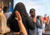 Immigrant Welfare Spike: Taxpayers on Edge Participants raising their hands during a citizenship oath ceremony