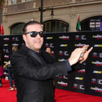 A man in sunglasses poses on the red carpet at a celebrity event