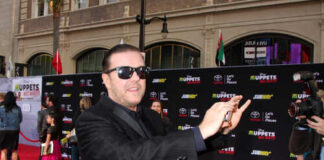 A man in sunglasses poses on the red carpet at a celebrity event