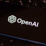 Close-up of a smartphone displaying the OpenAI logo on a dark screen