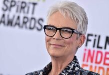 A smiling woman with short gray hair and glasses at a film awards event