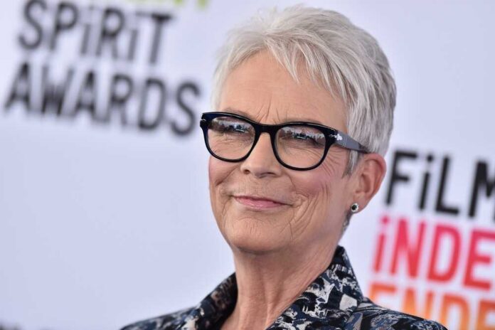 A smiling woman with short gray hair and glasses at a film awards event