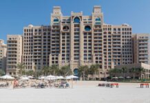 Iran’s Missiles TORCH Dubai’s Luxury Icons A luxury hotel by the beach with sun loungers and palm trees