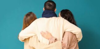 Three people embracing each other from behind against a teal background