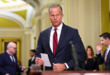 A government official holding a document in a formal setting