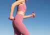 Woman exercising outdoors with pink dumbbells