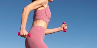 Woman exercising outdoors with pink dumbbells