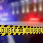 Yellow police caution tape with the text 'POLICE LINE DO NOT CROSS' in a blurred background