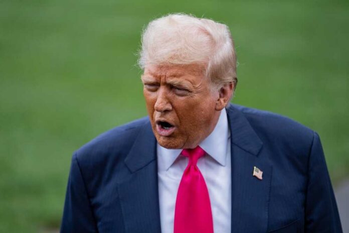 A political figure speaking outdoors with an expressive gesture