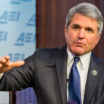 A man in a suit speaking during a conference