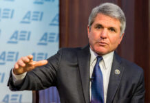 A man in a suit speaking during a conference
