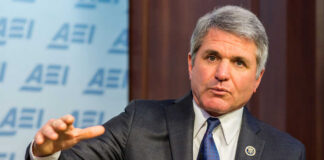 A man in a suit speaking during a conference