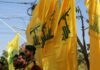 Hezbollah Missiles Ignite Regional Tensions Men standing with yellow flags wearing green berets