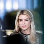 Woman with long blonde hair wearing hoop earrings