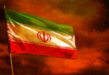 Iranian flag waving against a dramatic orange sky