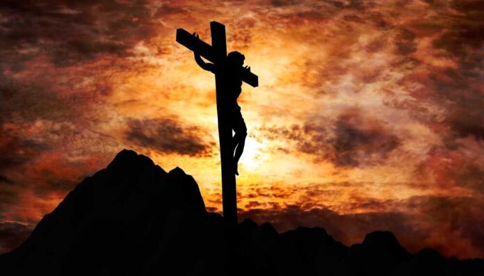 shutterstock_2133727155.jpg Silhouette of a crucifix against a dramatic sunset sky