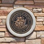 Bronze emblem of the Department of the Navy mounted on a stone wall