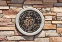 Bronze emblem of the Department of the Navy mounted on a stone wall