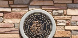 Bronze emblem of the Department of the Navy mounted on a stone wall