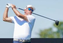 A golfer in mid-swing on a sunny day