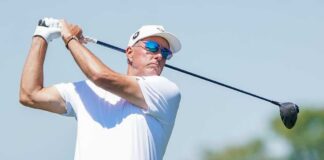 A golfer in mid-swing on a sunny day