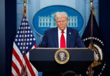 A political figure at a podium during a press conference