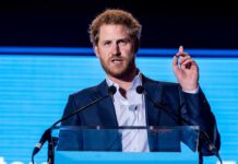 A man in a suit speaking at a podium during a conference