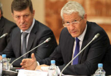 Two men engaged in a serious discussion during a meeting