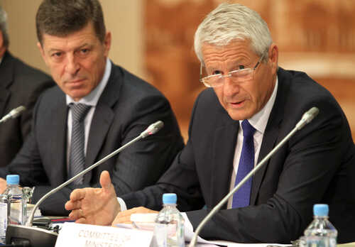 Two men engaged in a serious discussion during a meeting