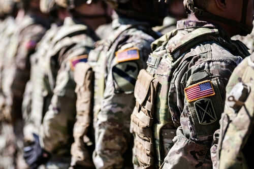 us-military_2321207565 Soldiers in camouflage with American flag patches standing