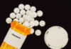 Prescription bottle of fentanyl tablets scattered on surface